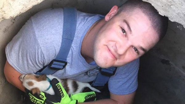 Haines City firefighter Mitch Lamm in the storm sewer where the puppy was found. Haines City Fire Dept. photo