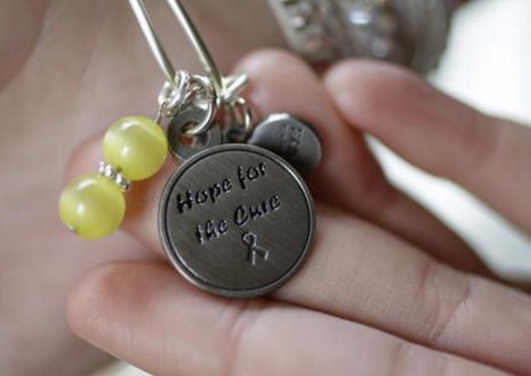 In this Wednesday, May 4, 2016 photo Emma Schambers, 18, of East Greenwich, R.I., displays a bracelet with a charm and beads she wears in memory of her late friend Catherine Malatesta, in East Greenwich. Malatesta died Aug. 2, 2015, eight months...