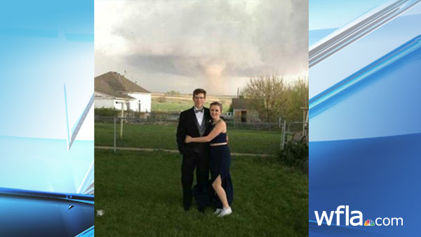 In this Saturday, May 7, 2016, photograph provided courtesy of Heidi Marintzer and taken with a mobile phone, Charlie Bator, left, and Ali Jolie Marintzer pose for a photograph before going to prom at the local high school as a tornado skips...