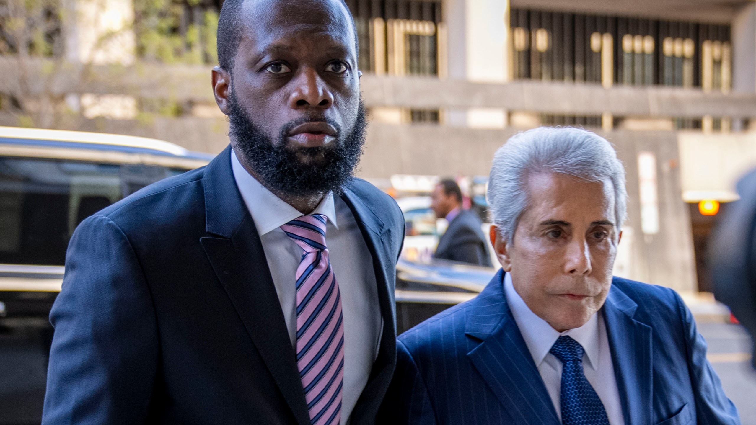 FILE - Prakazrel "Pras" Michel, left, a member of the 1990s hip-hop group the Fugees, accompanied by defense lawyer David Kenner, right, arrives at federal court for his trial in an alleged campaign finance conspiracy, Thursday, March 30, 2023, in Washington. Michel, who was accused in multimillion-dollar political conspiracies spanning two presidencies, was convicted Wednesday, April 26, after a trial that included testimony ranging from actor Leonardo DiCaprio to former U.S. Attorney General Jeff Sessions. (AP Photo/Andrew Harnik, File)