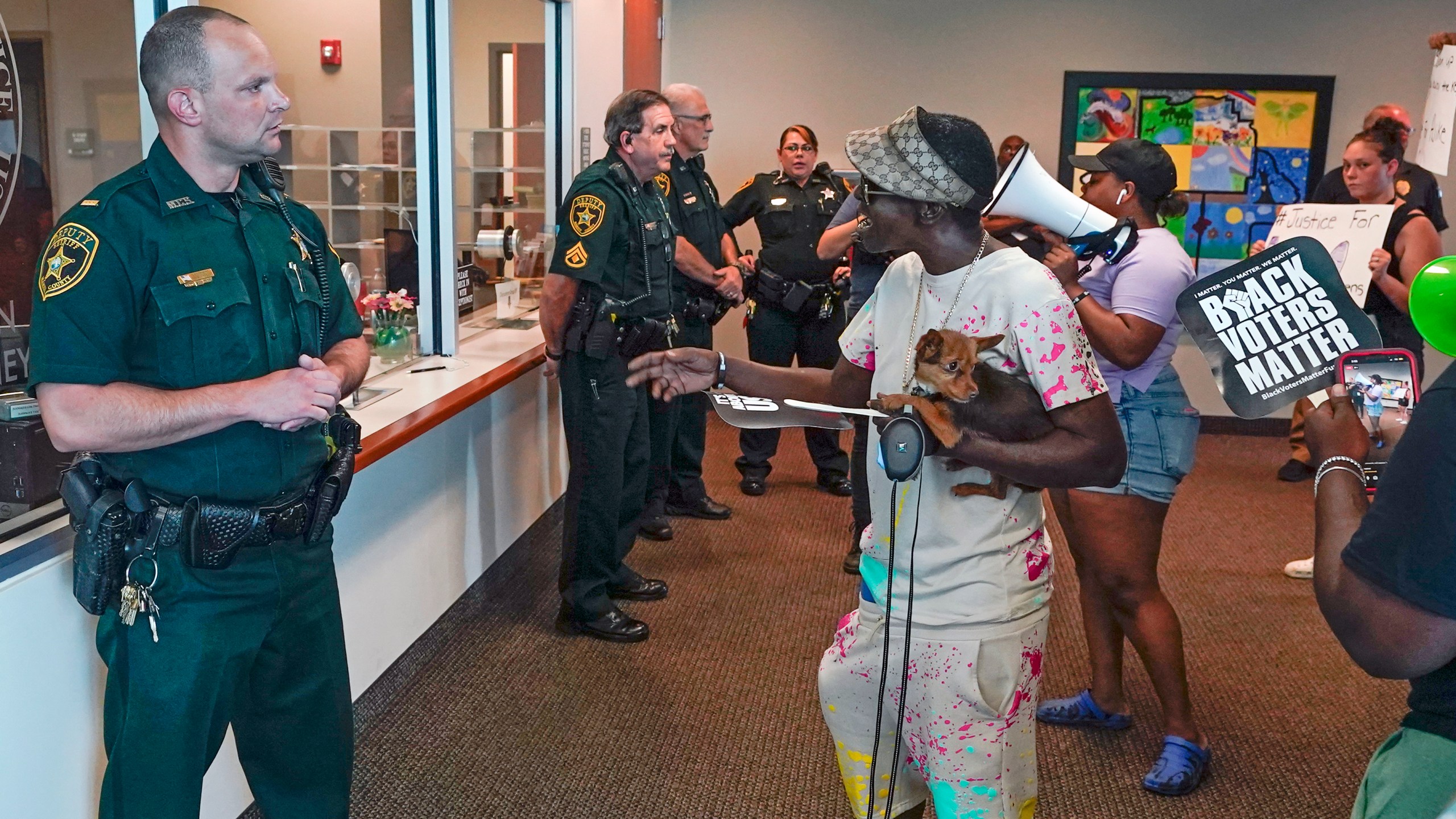 Protesters confront Marion County sheriff deputy's at the Marion County Courthouse, Tuesday, June 6, 2023, in Ocala, Fla. Authorities came under intense pressure to bring charges against a white woman who killed Ajike Owens, a 35-year-old mother of four, a Black neighbor, on her front doorstep, as they navigated Florida’s divisive stand your ground law that provides considerable leeway to the suspect in making a claim of self defense. (AP Photo/John Raoux)