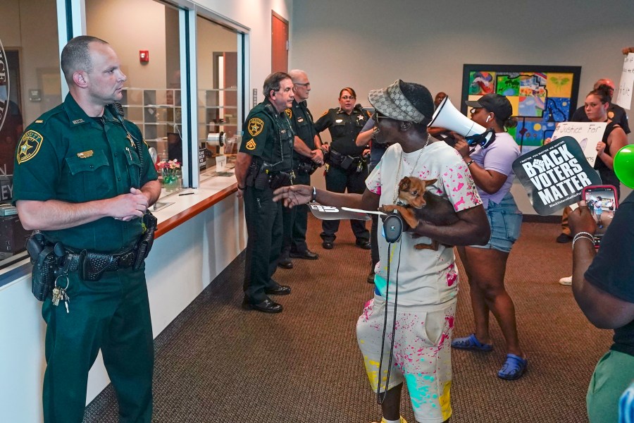 Protesters confront Marion County sheriff deputy's at the Marion County Courthouse, Tuesday, June 6, 2023, in Ocala, Fla. Authorities came under intense pressure to bring charges against a white woman who killed Ajike Owens, a 35-year-old mother of four, a Black neighbor, on her front doorstep, as they navigated Florida’s divisive stand your ground law that provides considerable leeway to the suspect in making a claim of self defense. (AP Photo/John Raoux)