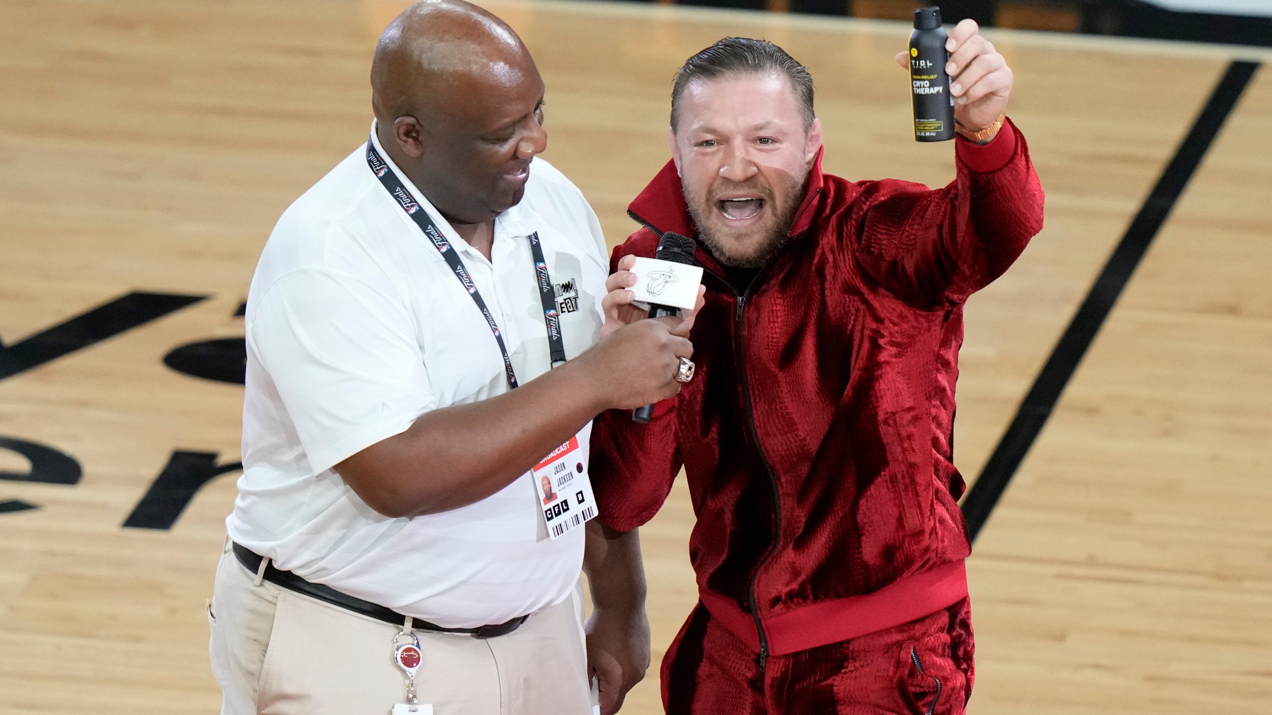 Former UFC champion Conor McGregor promotes a pain-relief spray during a break in Game 4 of the basketball NBA Finals between the Miami Heat and the Denver Nuggets, Friday, June 9, 2023, in Miami. (AP Photo/Lynne Sladky)