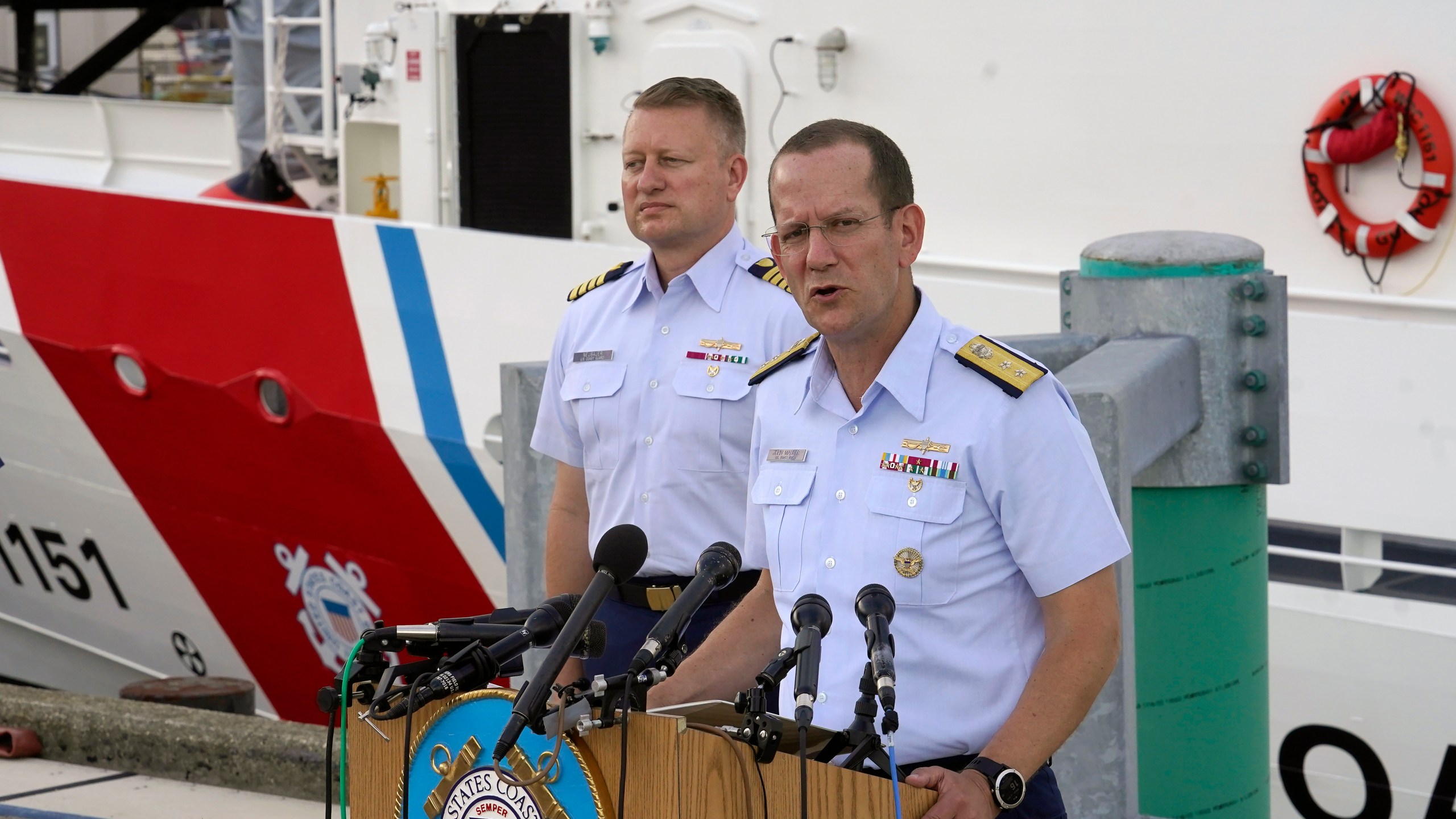 U.S. Coast Guard Rear Adm. John Mauger, commander of the First Coast Guard District, right, speaks to members of the media as Capt. Jason Neubauer, chief investigator, U.S. Coast, left, looks on during a news conference, Sunday, June 25, 2023, at Coast Guard Base Boston, in Boston. The U.S. Coast Guard said it is leading an investigation into the loss of the Titan submersible that was carrying five people to the Titanic, to determine what caused it to implode. (AP Photo/Steven Senne)