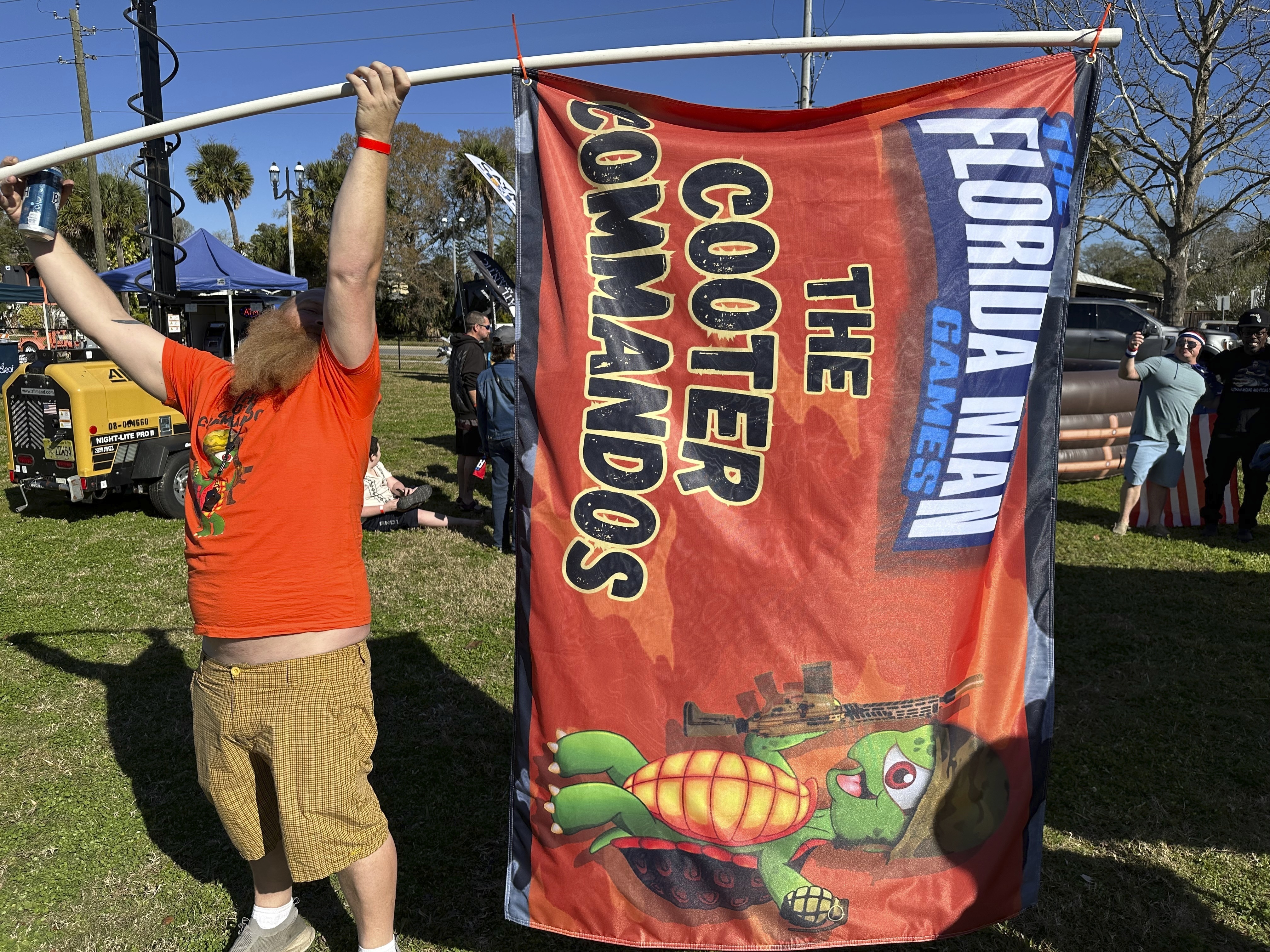 Andrew Peterson waves a flag for the team Cooter Commandos at the Florida Man Games on Saturday, Feb. 24, 2024, in St. Augustine, Fla. (AP Photo/Russ Bynum)