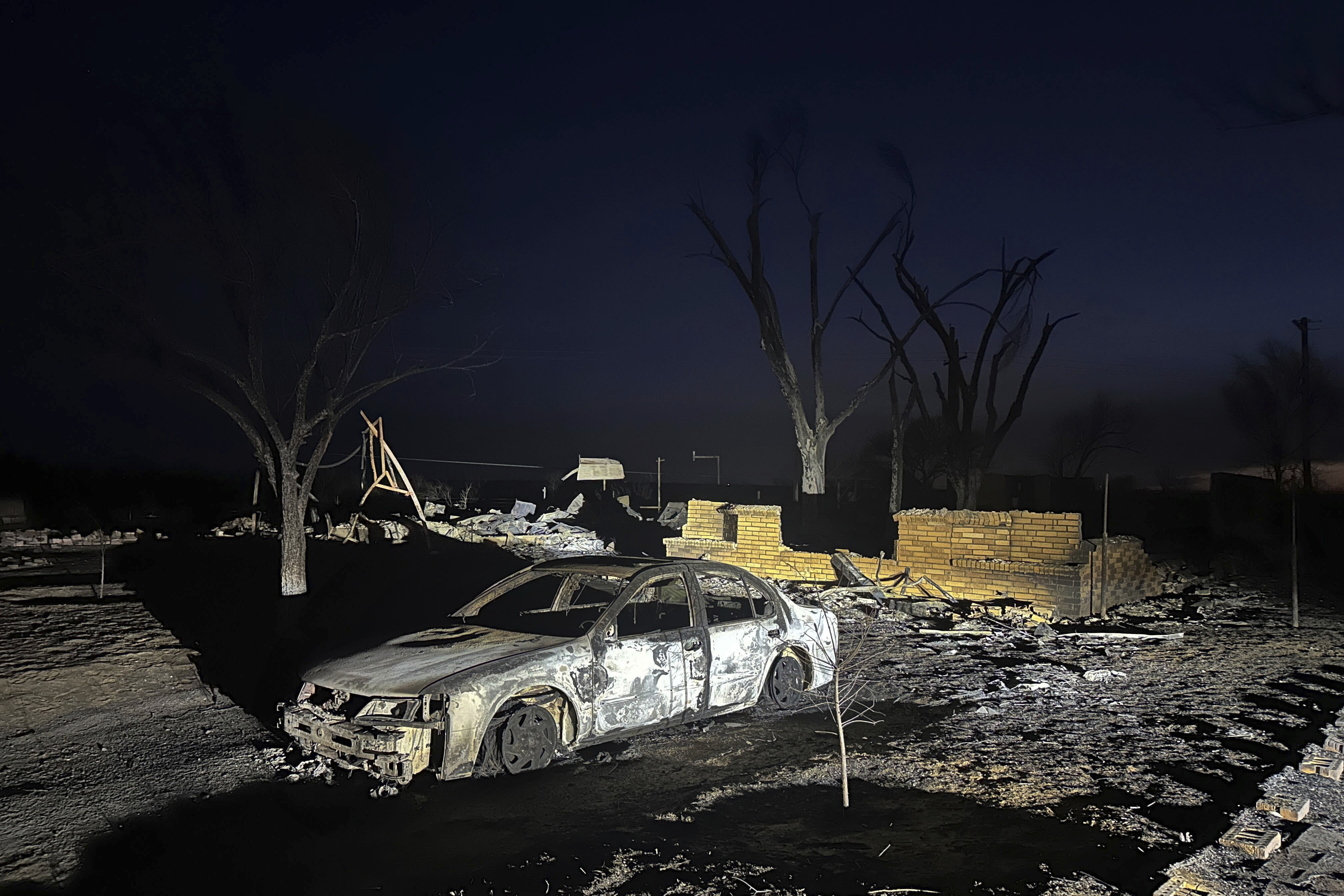 FILE - A charred vehicle sits near the ruins of a home after the property was burned by the Smokehouse Creek Fire, Wednesday, Feb. 28, 2024, in Fritch, Texas. Fritch Fire Chief Zeb Smith, whose small town was among the hardest hit last week by historic blazes sweeping across the Panhandle, died Tuesday, March 5, 2024, while fighting a structure fire, authorities said. (AP Photo/Ty O'Neil, File)