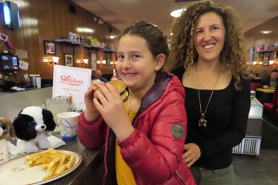 Evie Polera, left, and her mother Dara Polera, right, eat on March 5, 2024, at the counter of Holsten's, the Bloomfield N.J. ice cream parlor and restaurant where the final scene of "The Sopranos" TV series was filmed. A day earlier, the booth where Tony Soprano may or may not have met his end was sold in an online auction for $82,600 to a buyer that wishes to remain anonymous. (AP Photo/Wayne Parry)