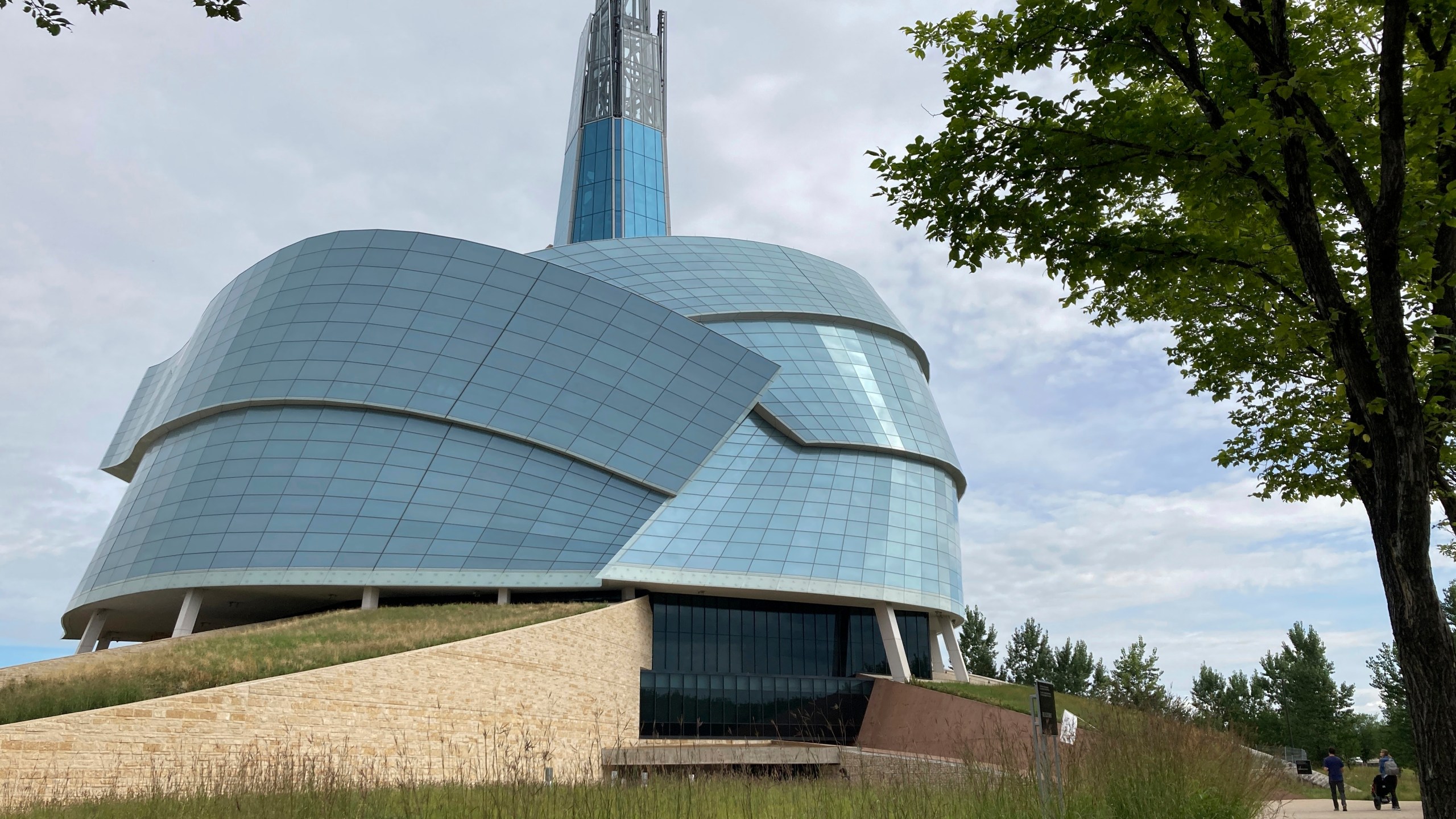 People walk by the Canadian Museum for Human Rights, created by internationally renowned architect Antoine Predock on Aug. 13, 2023, in Winnipeg, Manitoba. Predock, whose list of credits includes award-winning buildings around the world, died Saturday, March 2, 2024, at his home in Albuquerque, according to longtime friends and colleagues. He was 87. (AP Photo/Felicia Fonseca)