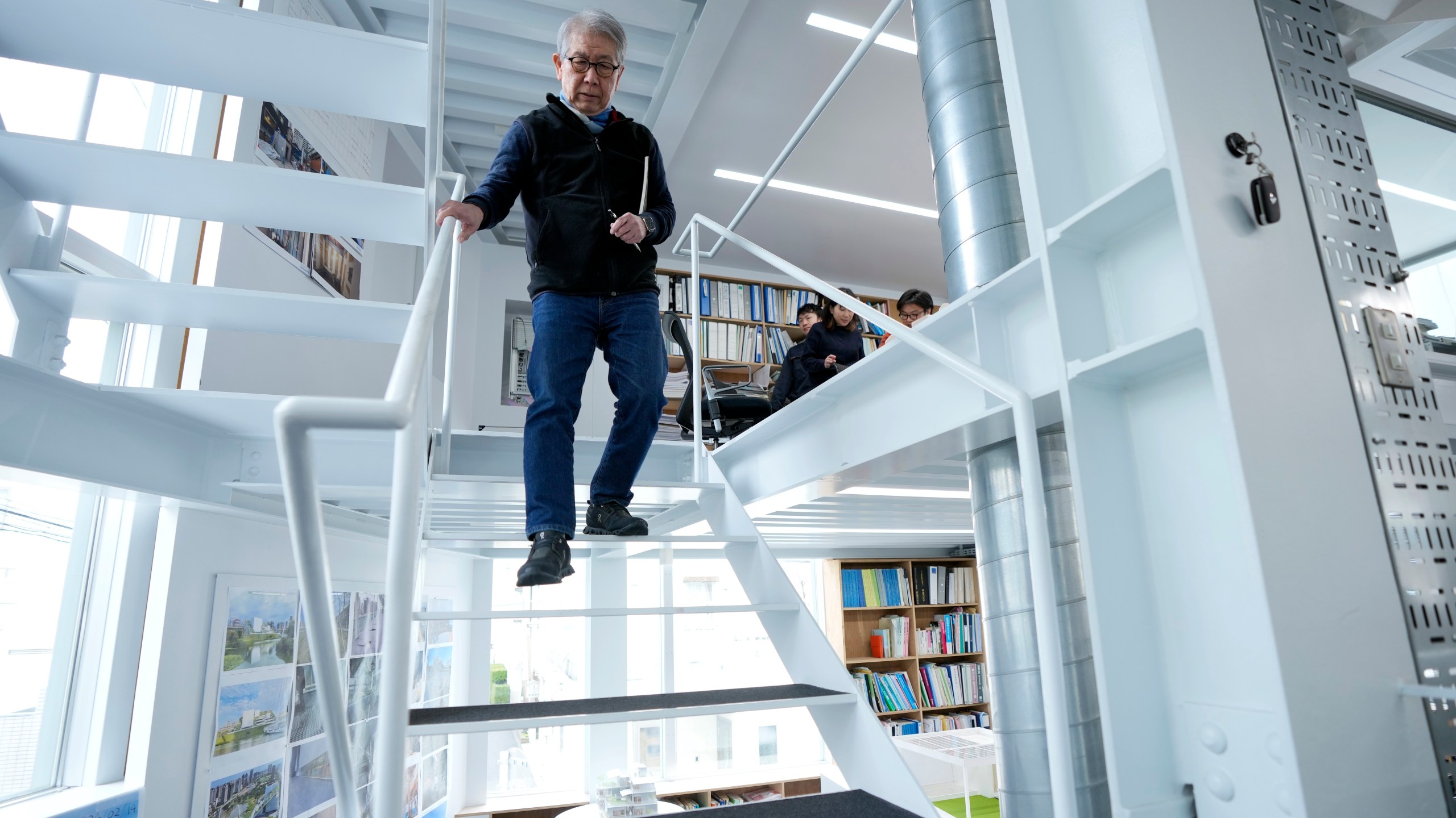 Japan's Riken Yamamoto, laureate of Pritzker Architecture Prize, walks down the stairs at his office Wednesday, March 6, 2024, in Yokohama near Tokyo. The Pritzker Architecture Prize has been awarded to Japan’s Riken Yamamoto, who earns the field’s highest honor for what organizers called a long career focused on "multiplying opportunities for people to meet spontaneously, through precise, rational design strategies." (AP Photo/Eugene Hoshiko)