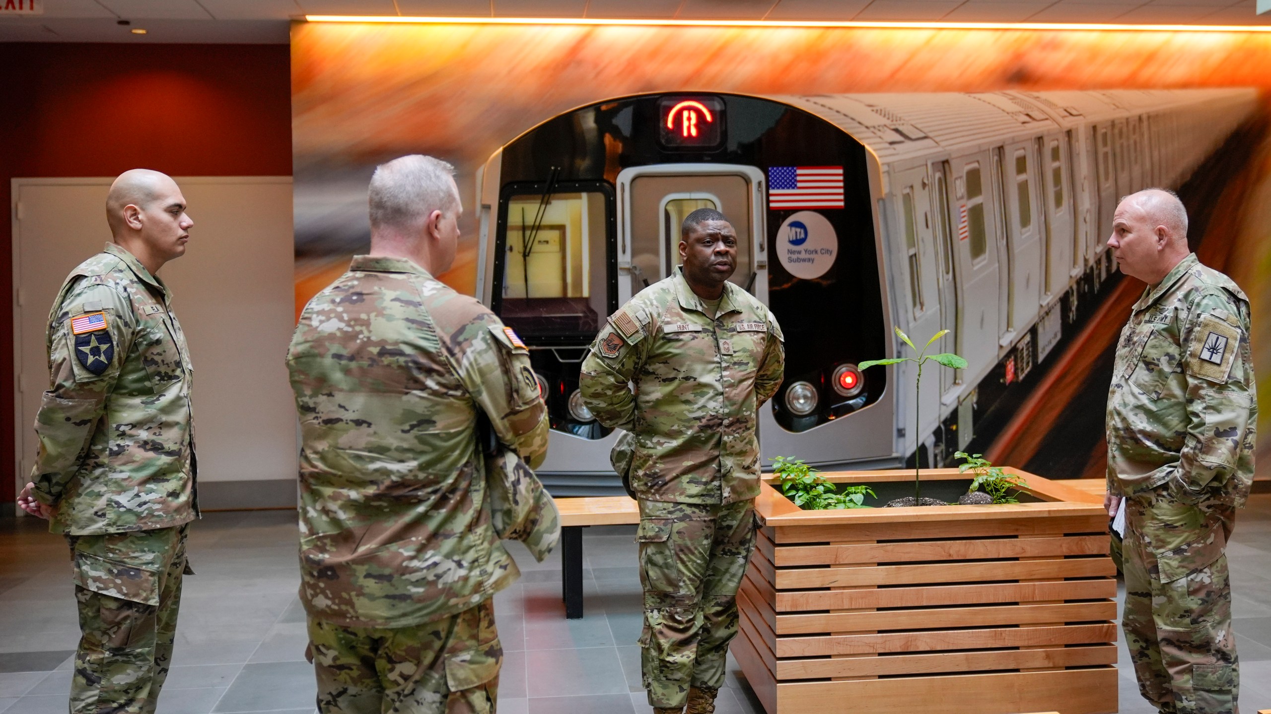 Members of the Armed Forces including the National Guard wait in the lobby of the New York City Mass Transit Authority Rail Control Center before the start of a news conference with Gov. Hochul, Wednesday, March 6, 2024, in New York. Hochul is deploying the National Guard to the New York City subway system to help police search passengers' bags for weapons, following a series of high profile crimes on city trains. (AP Photo/Mary Altaffer)